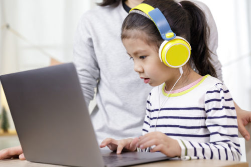 Image of a young girl using a laptop to learn