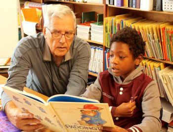 Tutor John Candelaria reading with student