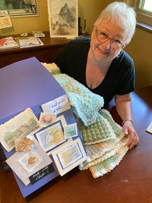 Mary Dorney with some of her watercolor and crochet creations.